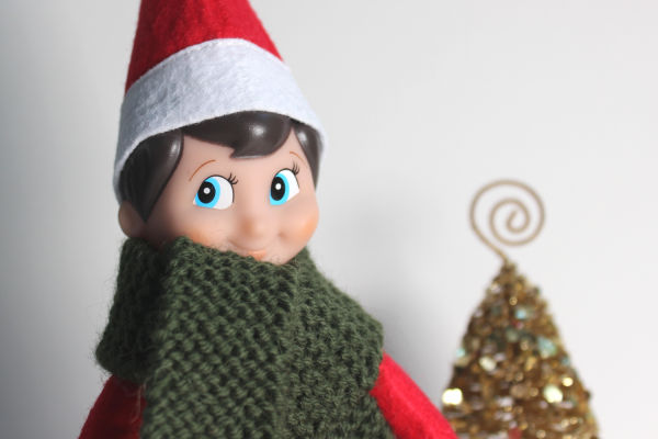 An Elf on the shelf in a snuggly handknit scarf.